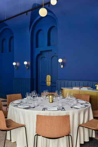a blue room with a table and chairs with glasses at W Budapest in Budapest