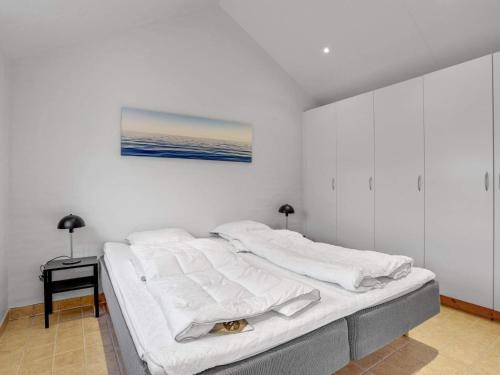 ein weißes Schlafzimmer mit einem Bett, auf dem eine Katze liegt in der Unterkunft Charming Haven in Lokken - By Traum Ferienwohnungen in Løkken