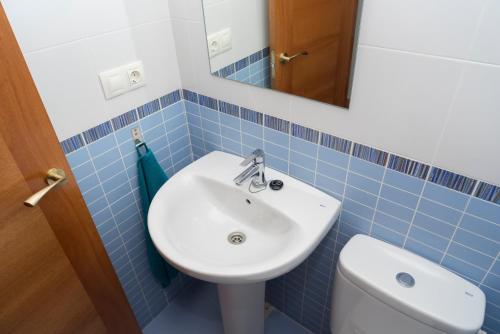 チュリリャにあるMiralrio Chulillaの青いタイル張りのバスルーム(洗面台、トイレ付)
