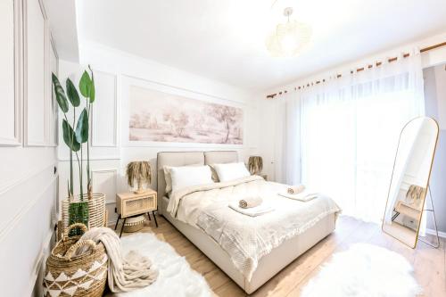 a white bedroom with a bed and a window at Premium Beachfront Residences in Durrës