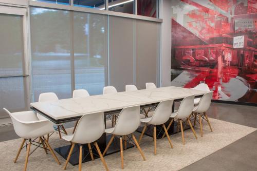 a conference room with a white table and chairs at Aloft Raleigh in Raleigh