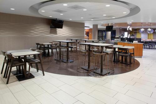 a restaurant with tables and chairs in a cafeteria at SpringHill Suites Cincinnati North Forest Park in Springdale