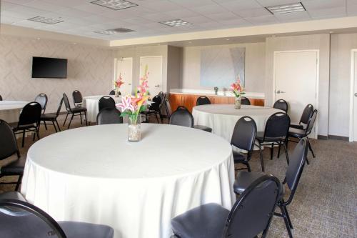 a conference room with two tables and chairs with flowers on them at SpringHill Suites Cincinnati North Forest Park in Springdale
