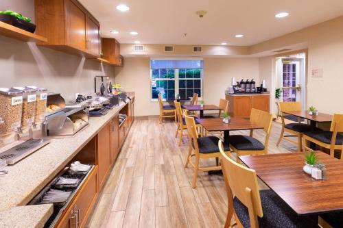 a kitchen and dining room with wooden tables and chairs at TownePlace Suites Bowie Town Center in Bowie