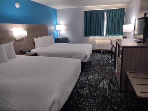 a hotel room with two beds and a flat screen tv at Baymont by Wyndham Duluth Spirit Mountain in Duluth