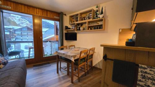 Cette chambre dispose d'un balcon et d'une table avec des chaises. dans l'établissement Appartement proche télécabine! Séjour tout inclu!, aux Contamines-Montjoie