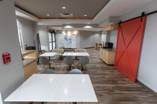 a room with tables and chairs and a red door at TownePlace Suites by Marriott Bowling Green in Bowling Green