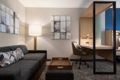 a living room with a couch and a desk at SpringHill Suites by Marriott Milwaukee West/Wauwatosa in Wauwatosa