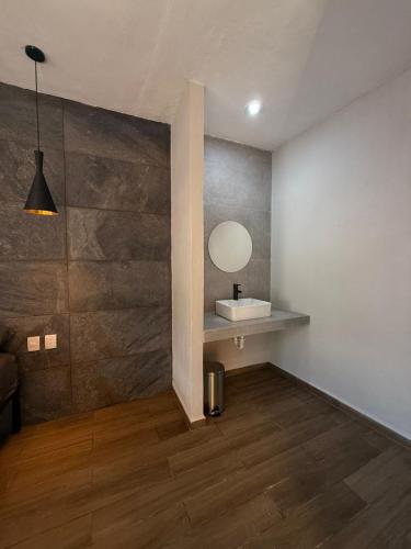 a bathroom with a sink and a mirror on a wall at La Gran Manzana in Tizimín