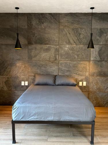 a bed in a room with two lights above it at La Gran Manzana in Tizimín