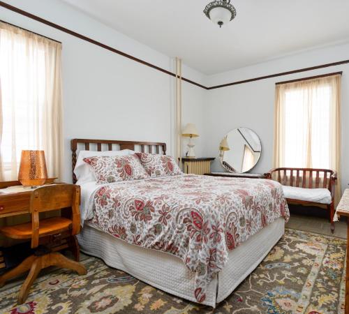 a bedroom with a bed and a table and a mirror at Royal Hotel Sydney in Sydney