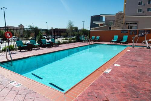a large swimming pool with blue chairs in a building at Residence Inn by Marriott Oklahoma City Northwest in Oklahoma City