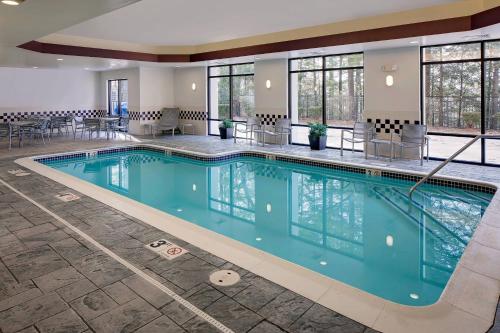 a swimming pool in a hotel with tables and chairs at SpringHill Suites Manchester-Boston Regional Airport in Manchester