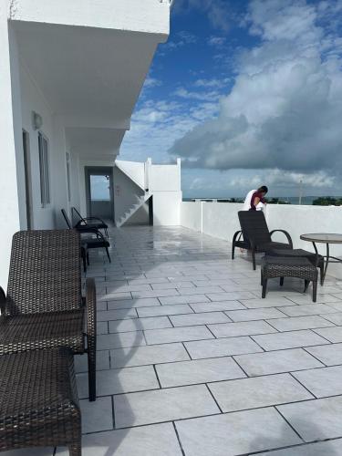 a person sitting on a balcony with chairs and tables at SKY INN in Caye Caulker