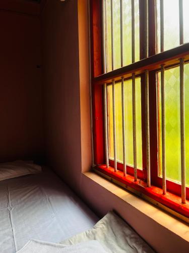 a window in a room with a bed next to it at Village Oasis Retreat in Haldipur