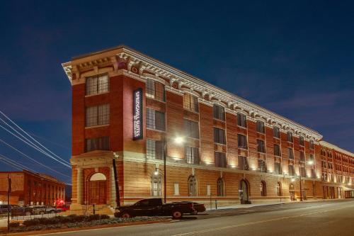 a large brick building with a truck parked in front of it at SpringHill Suites by Marriott Montgomery Downtown in Montgomery