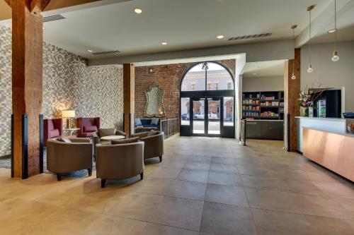a lobby with chairs and tables and a bar at SpringHill Suites by Marriott Montgomery Downtown in Montgomery