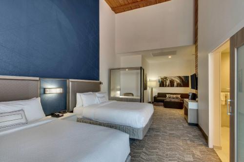 a hotel room with two beds and a living room at SpringHill Suites by Marriott Montgomery Downtown in Montgomery
