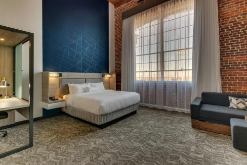 a hotel room with a bed and a couch at SpringHill Suites by Marriott Montgomery Downtown in Montgomery