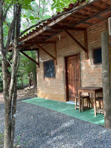 a wooden cabin with a table and a wooden door at Quintal De Minas in Delfinópolis