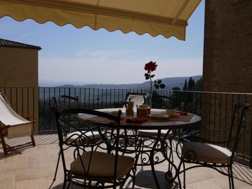 einen Tisch und Stühle auf einem Balkon mit Aussicht in der Unterkunft Il Corso in Montepulciano