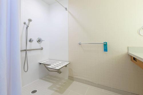a white bathroom with a shower and a sink at SpringHill Suites by Marriott Raleigh Cary in Cary