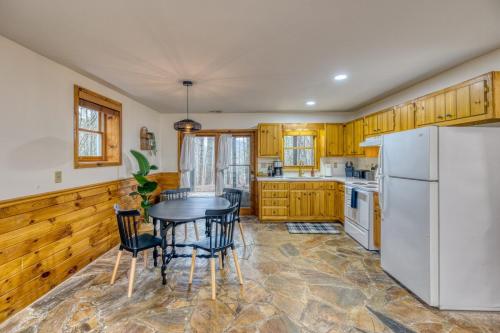 a kitchen with a table and a white refrigerator at Cozy Cabin With Hot Tub, Grill, Fire Pit & Game Room in Blue Ridge