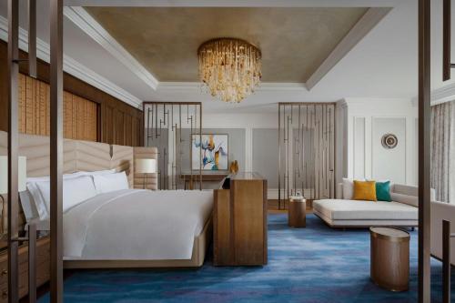 a bedroom with a large bed and a chandelier at The Ritz-Carlton, Baku in Baku