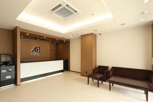 vestíbulo de un hotel con escritorio y sillas en AB Hotel Anjo, en Anjomachi