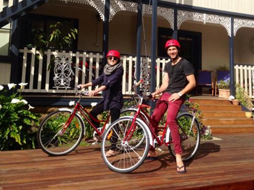 a man and woman riding bikes on a deck at Montacute Boutique Bunkhouse in Hobart
