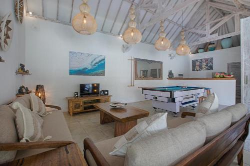 a living room with couches and a pool table at Villas Shiva, Cahaya & Bulan Complex - Bingin, Uluwatu in Uluwatu