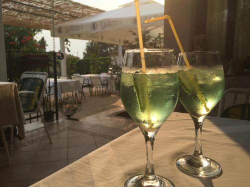 dois copos de vinho branco sentados numa mesa em Vera Bed and Breakfast em Umag