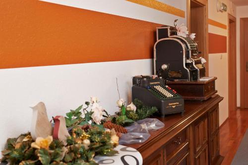 a desk with an old fashioned typewriter and flowers on it at Alpenmotel Säuling in Reutte