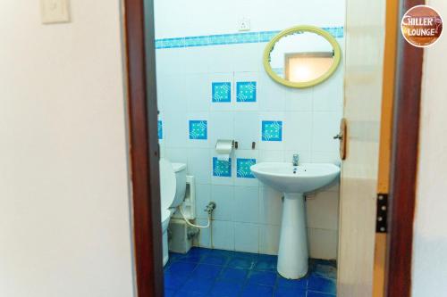 a bathroom with a sink and a toilet and a mirror at Chiller Jone's place in Tangalle