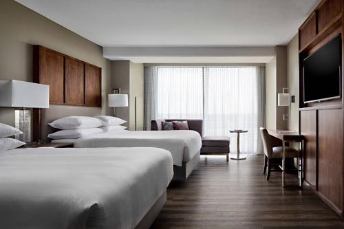 a hotel room with two beds and a television at Omaha Marriott Downtown at the Capitol District in Omaha