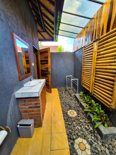 a bathroom with a sink and a mirror at Wadon Menjangan homestay in Banyuwedang