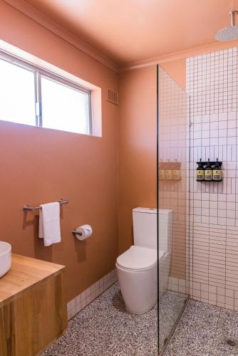 a bathroom with a toilet and a glass shower at The Lodge At The Denmark Hotel in Denmark
