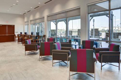 a waiting room with chairs and tables and windows at SpringHill Suites by Marriott Dallas Plano/Frisco in Plano