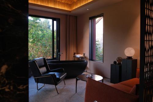 a living room with a bath tub and a chair at Topscape 仰山 in Qingdao