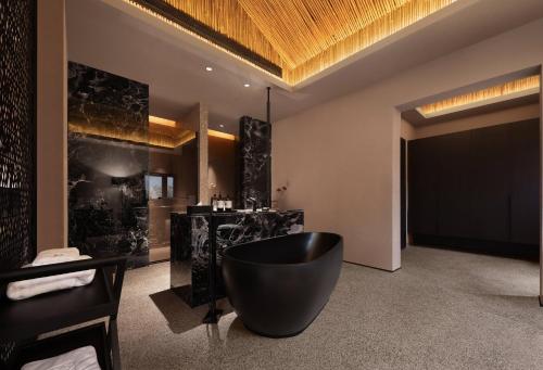 a bathroom with a large black tub in a room at Topscape 仰山 in Qingdao