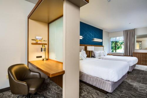 a hotel room with two beds and a desk at SpringHill Suites Vero Beach in Vero Beach