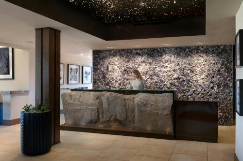 a woman standing at a counter in a lobby at Sky Rock Sedona, a Tribute Portfolio Hotel in Sedona