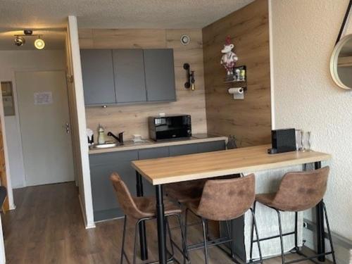 une cuisine avec un comptoir, une table et des chaises dans l'établissement Studio cabine 4 pers, 200m des pistes, animaux acceptés - FR-1-636-233, à Orcières