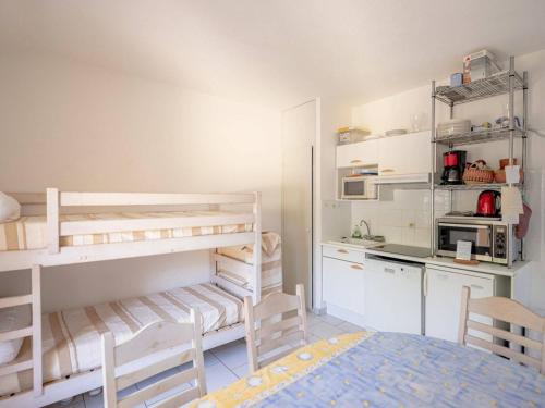 une chambre avec deux lits superposés et une cuisine dans l'établissement Appartement chaleureux avec terrasse et parking au Lavandou - FR-1-816-2, au Lavandou