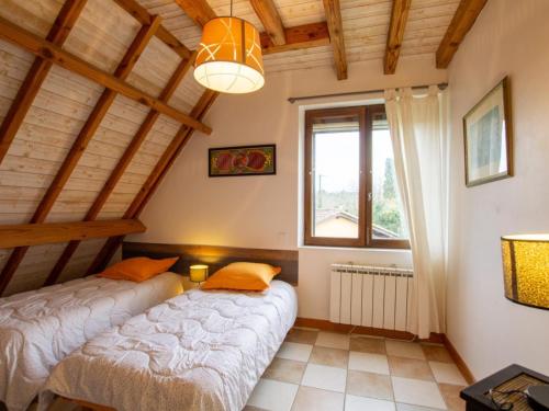 two beds in a room with a window at Évasion en Périgord: Gîte 4 chambres, terrasse, jardin, animaux bienvenus, près de Sarlat - FR-1-616-449 in Plazac