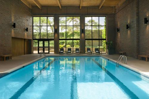 a large pool with blue water in a building with windows at The Westin Chicago Northwest in Itasca
