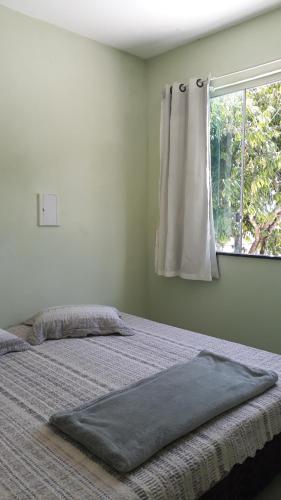 Un dormitorio con una cama grande con ventana. en Porto apartamento 1, en Porto Seguro