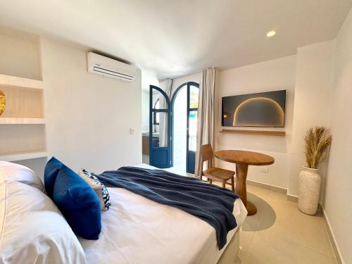 a bedroom with a bed and a table in it at Villa kalah in Puerto Triunfo