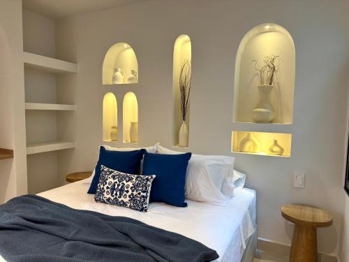 a bedroom with a bed with blue and white pillows at Villa kalah in Puerto Triunfo