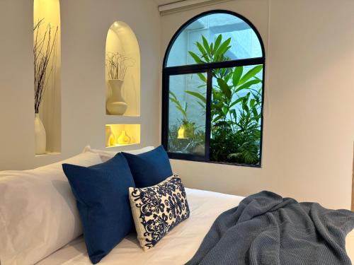 a bedroom with a window and a bed with blue pillows at Villa kalah in Puerto Triunfo